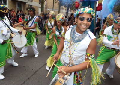 Troupe de musiciens et danseurs habillés en tenue de fête brésilienne défilant dans la rue