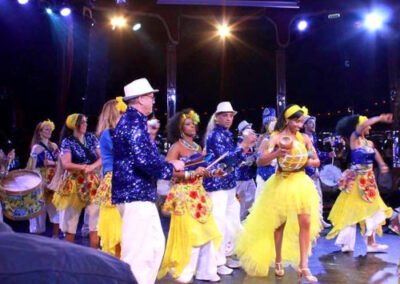 Troupe de musiciens et danseurs habillés en tenue de fête brésilienne sur scène