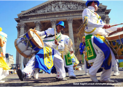 Quelques percussionnistes habillés en tenue de fête brésilienne défilant dans la rue