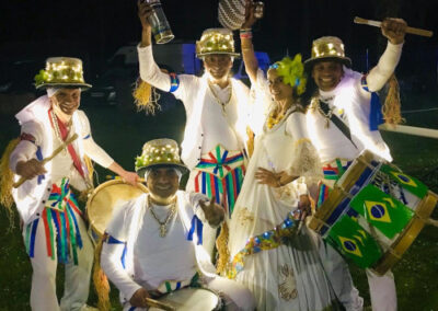 Musiciens et danseuses habillés en tenue de fête brésilienne posant pour la photo