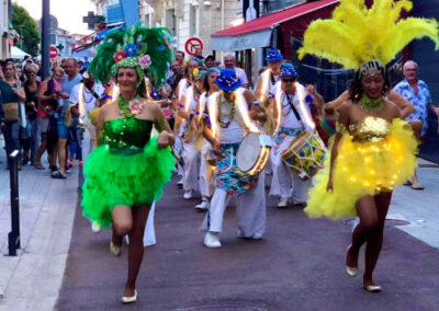 Musiciens et danseuses habillés en tenue de fête brésilienne, spectacle dans la rue