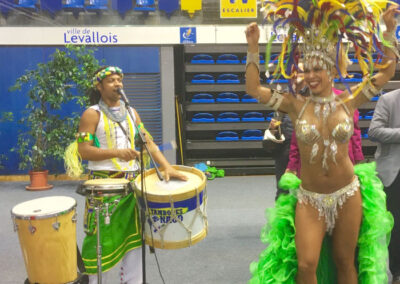 Homme jouant des percussions et danseuse, chacun en tenue de fête brésilienne